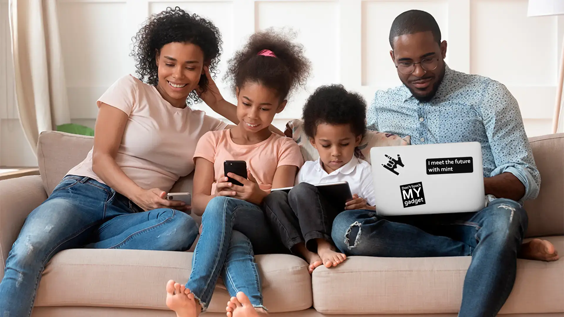 A photo of a family spending time together while using multiple devices, a laptop is branded with Mint logo.